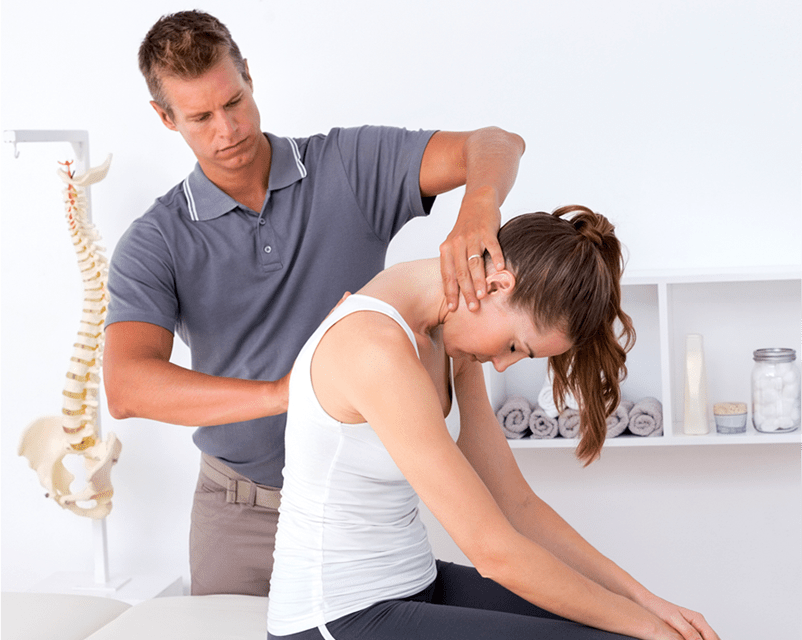 A woman receiving a neck massage from a physiotherapist at a Chiropractor.
