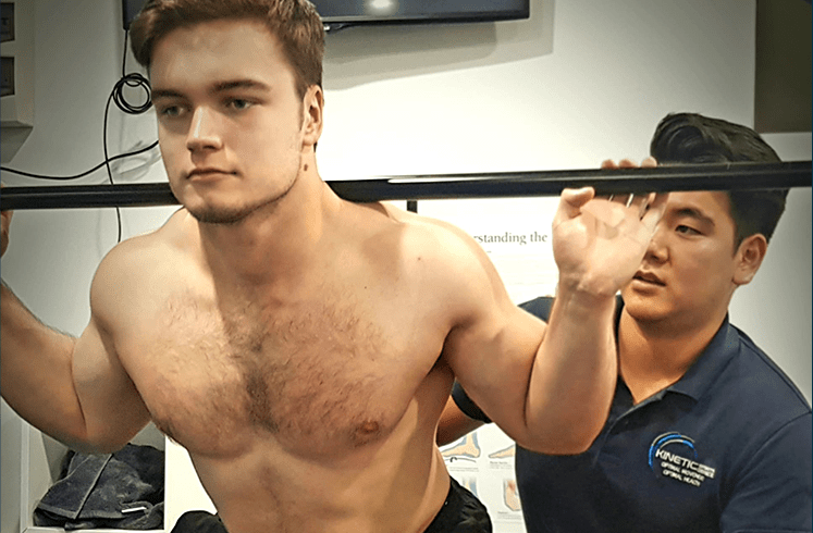 A man lifting weights at a gym.